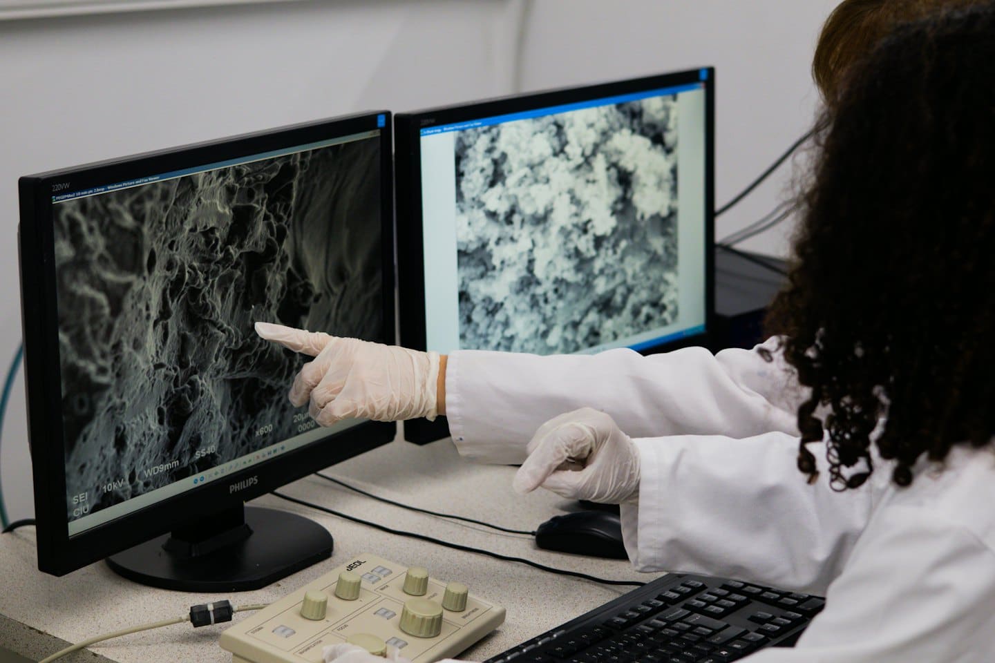 Výskumník analyzuje obraz z elektrónového mikroskopu na počítačových monitoroch v laboratóriu.